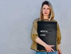 Laura Fröhlich hält ein Schild mit der Aufschrift mental load